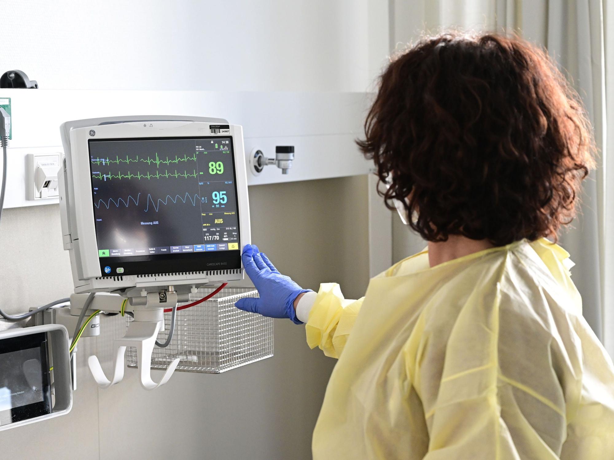 Eine Pflegerin schaut in einem Krankenzimmer im Klinikum Stuttgart auf einen Monitor einer Patientin, hier im Februar 2023.