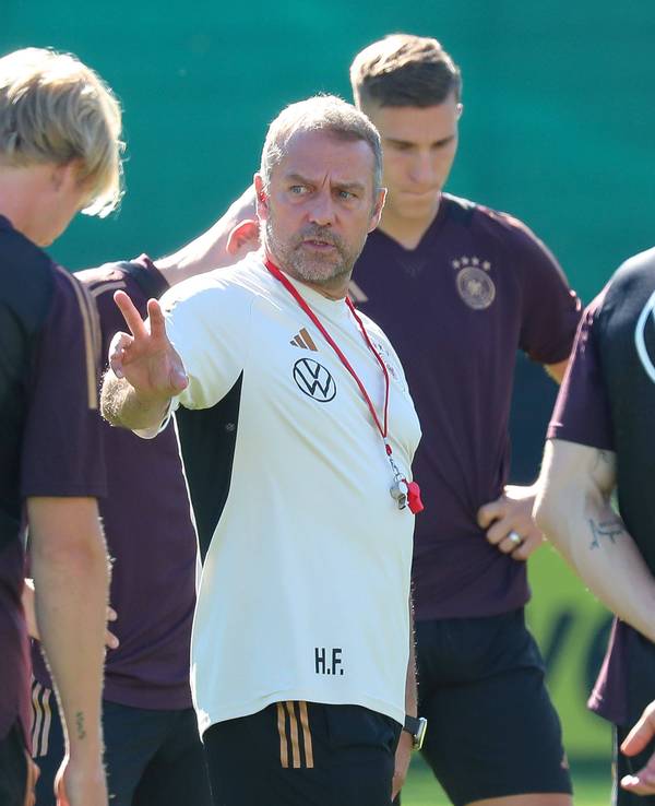 Hansi Flick spricht mit seinen Spielern auf dem Trainingsplatz.
