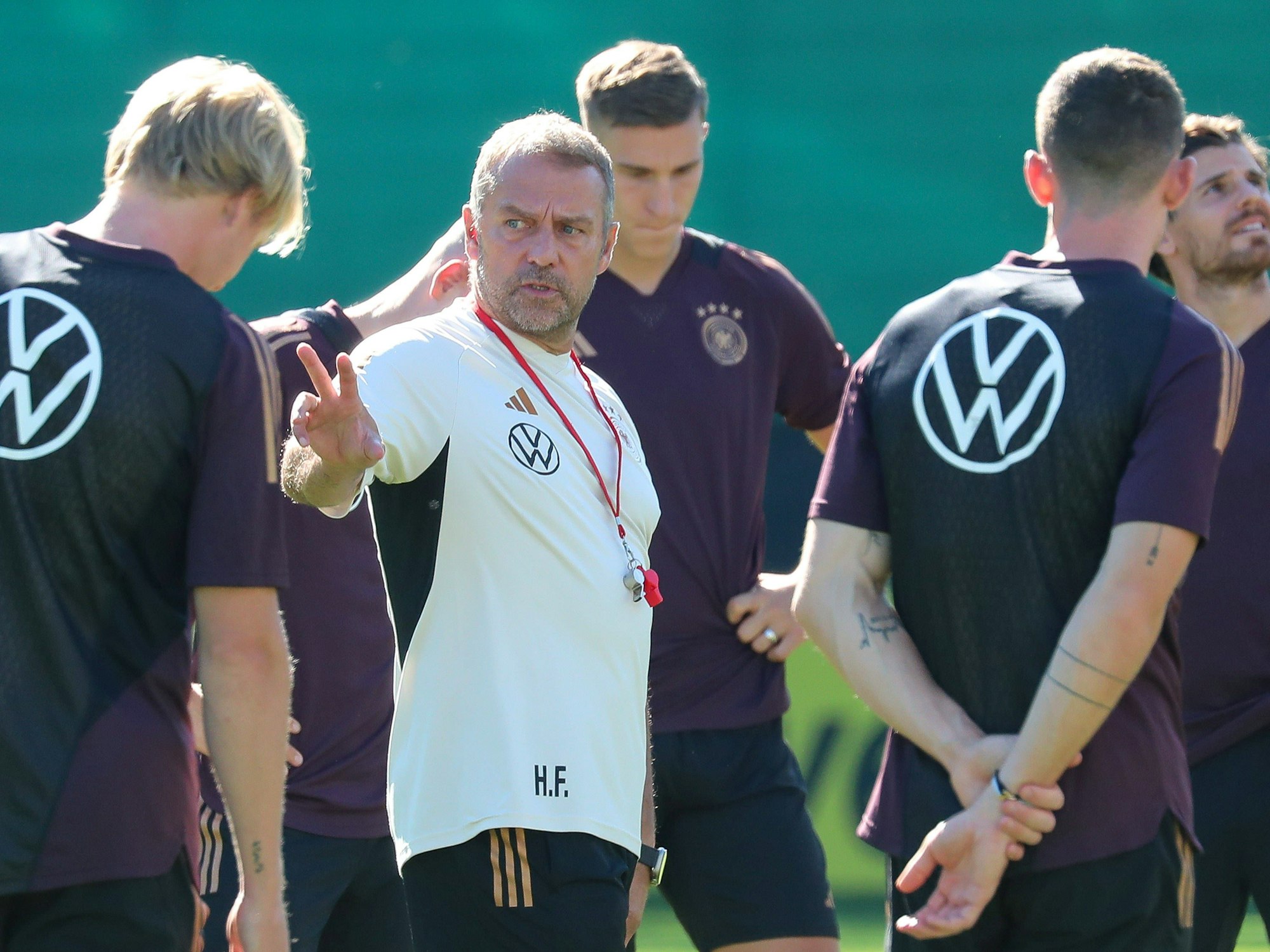 Hansi Flick spricht mit seinen Spielern auf dem Trainingsplatz.