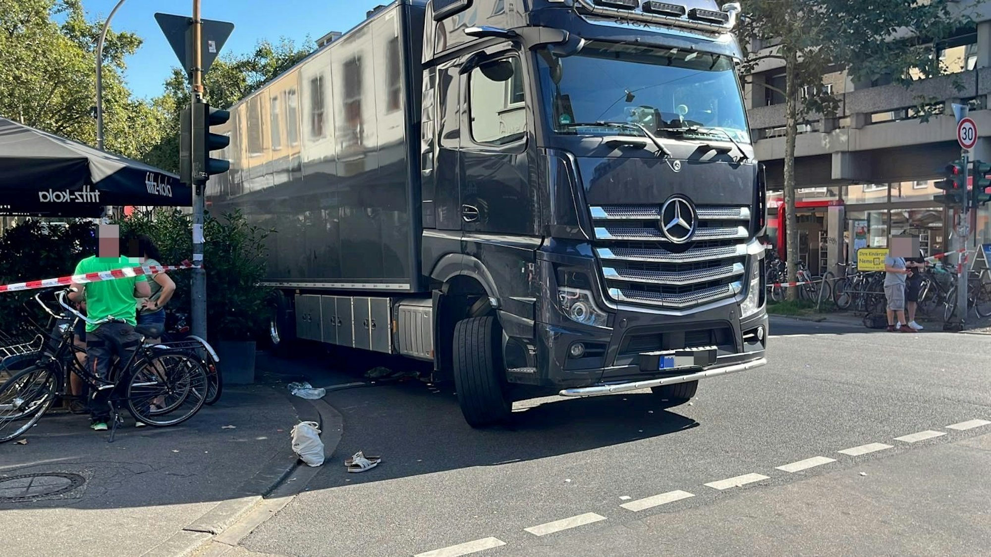 Der Lkw steht an der Unfallstelle. Auf der Fahrbahn liegt ein Schuh der erfassten Radfahrerin.