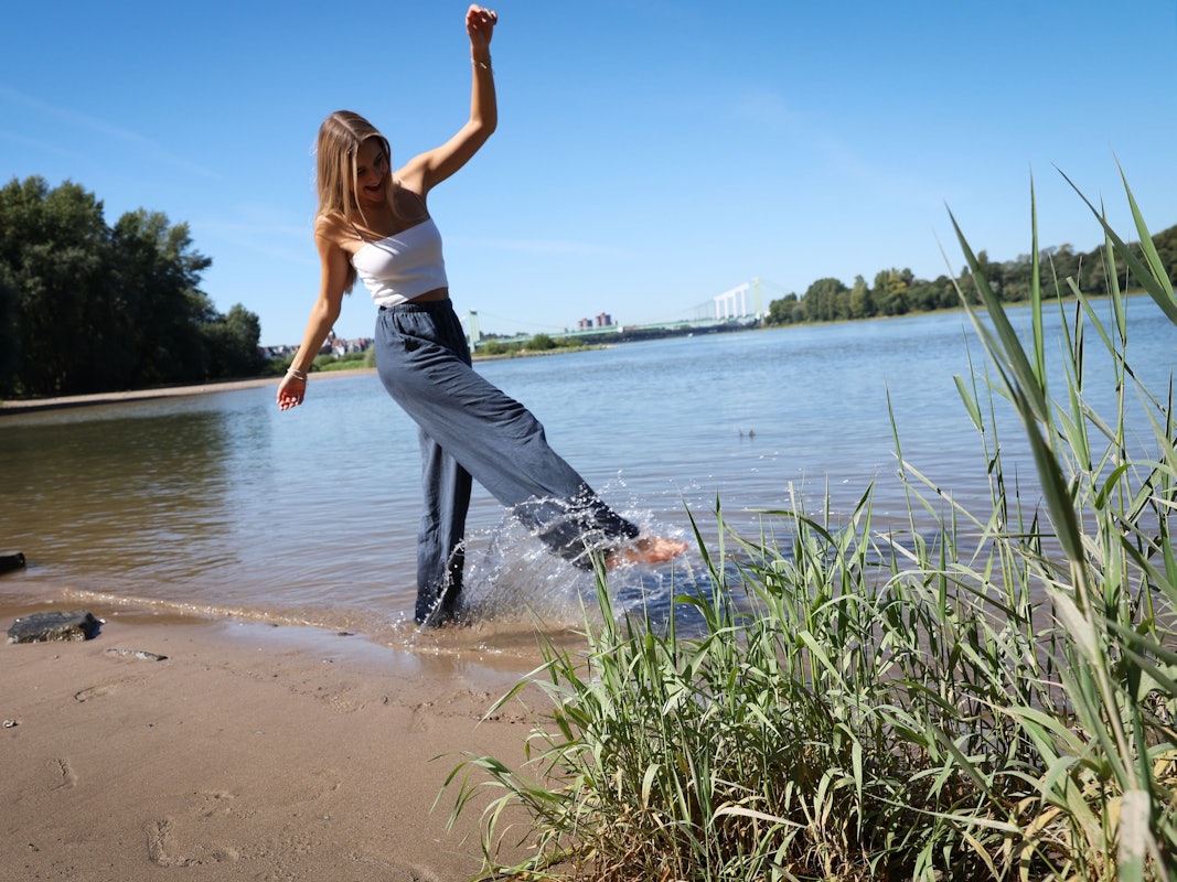 Eine Frau genießt am 6. September 2023 das schöne Wetter an der Rodenkirchener Riviera.