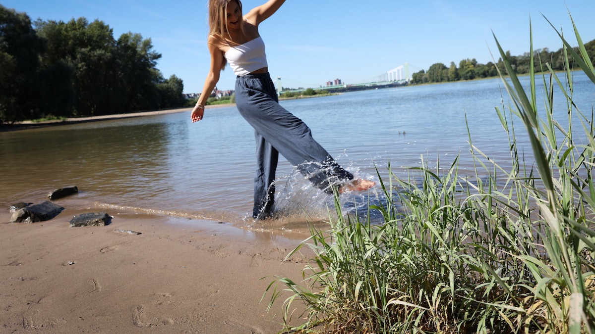 Eine Frau genießt am 6. September 2023 das schöne Wetter an der Rodenkirchener Riviera.