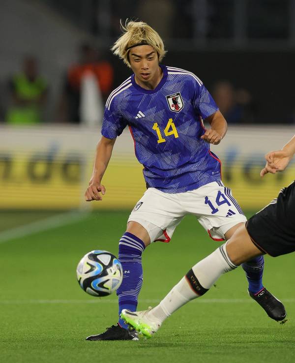 Japans Junya Ito (l) und Deutschlands Nico Schlotterbeck im Kampf um den Ball.