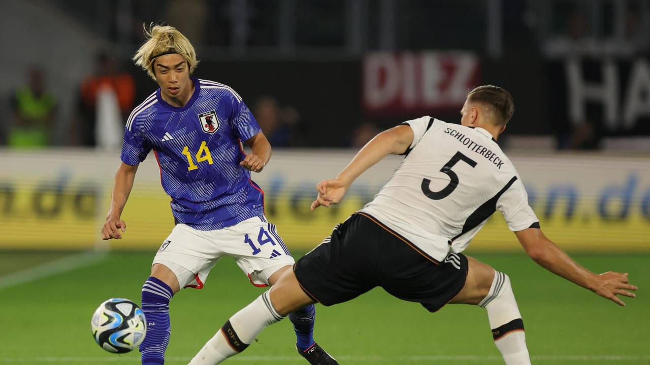 Japans Junya Ito (l) und Deutschlands Nico Schlotterbeck im Kampf um den Ball.