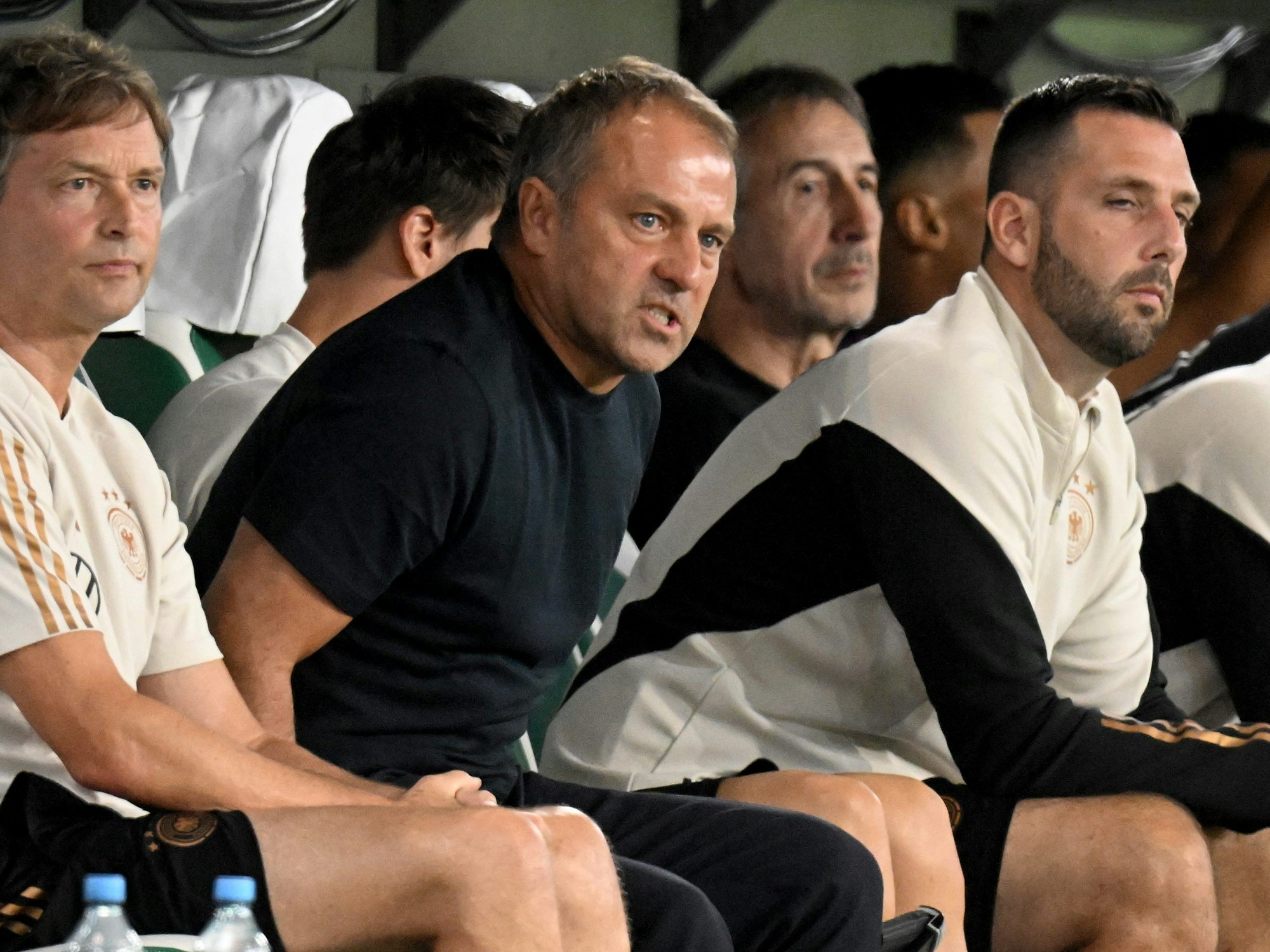 Bundestrainer Hansi Flick (M.) sitzt auf der Bank.