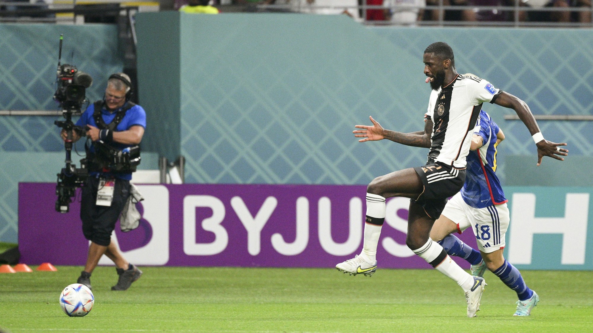 Takuma Asano und Antonio Rüdiger im Laufduell in der WM-Gruppenphase am 23. November 2022 in Katar.