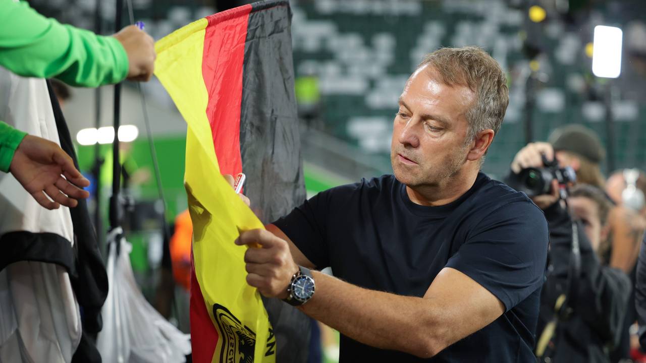Hansi Flick unterschreibt auf der Deutschland-Flagge eines Fans.