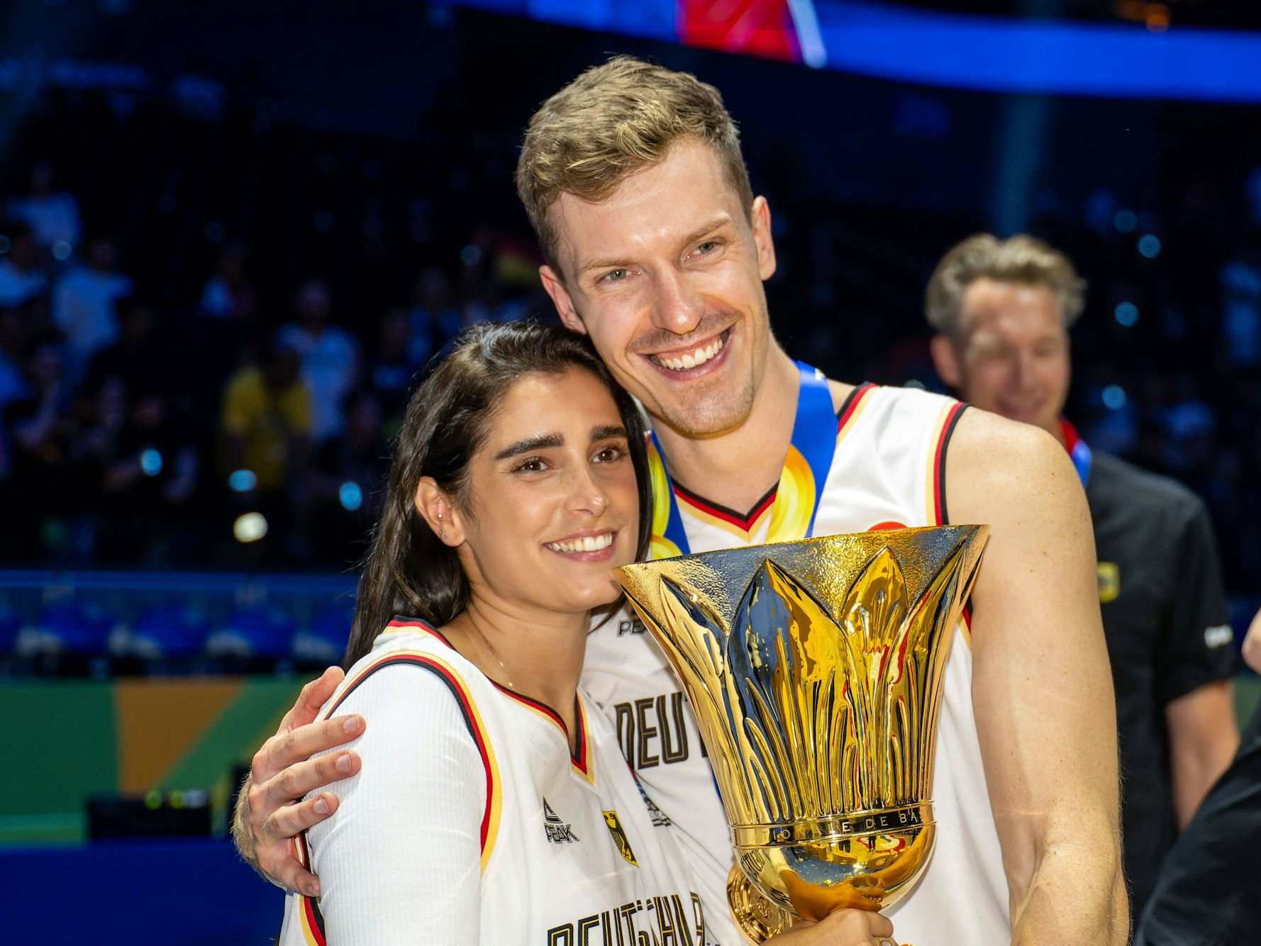 Andreas Obst posiert mit Ines und dem WM-Pokal.