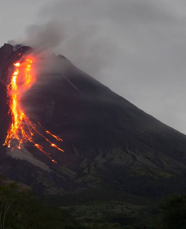 Ein Vulkankrater, aus dem glühende Magma hinausläuft.