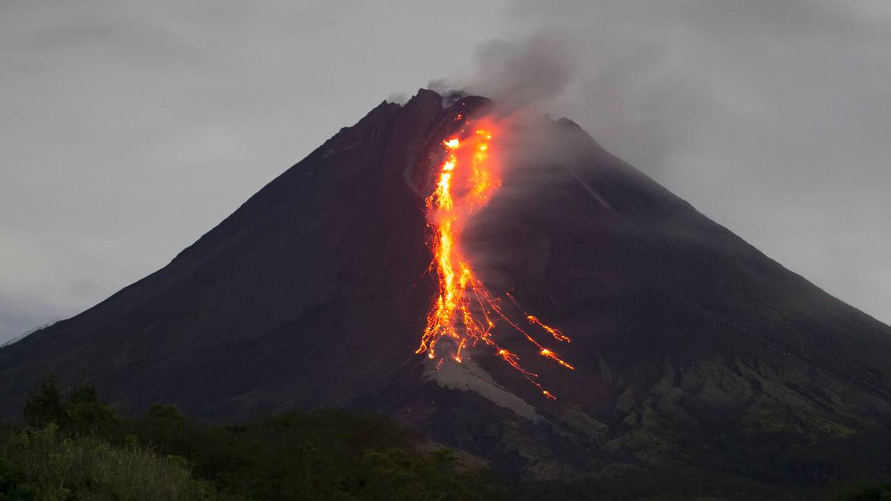 Ein Vulkankrater, aus dem glühende Magma hinausläuft.