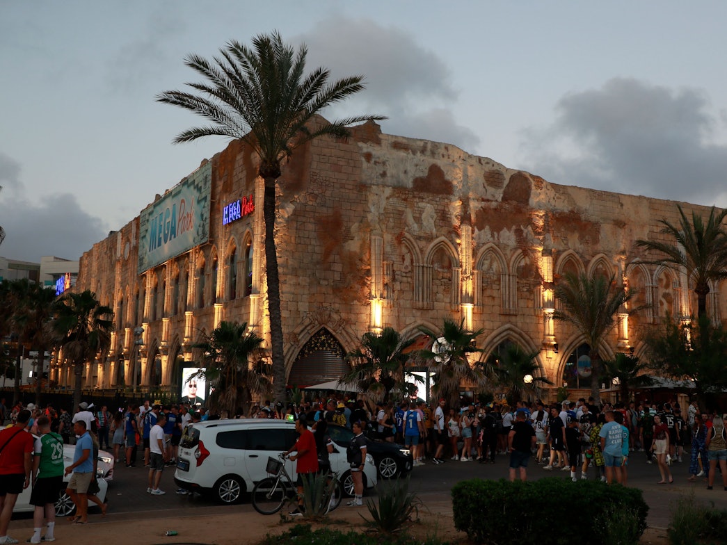 Zahlreiche Menschen stehen vor dem Megapark am Strand von Arenal.