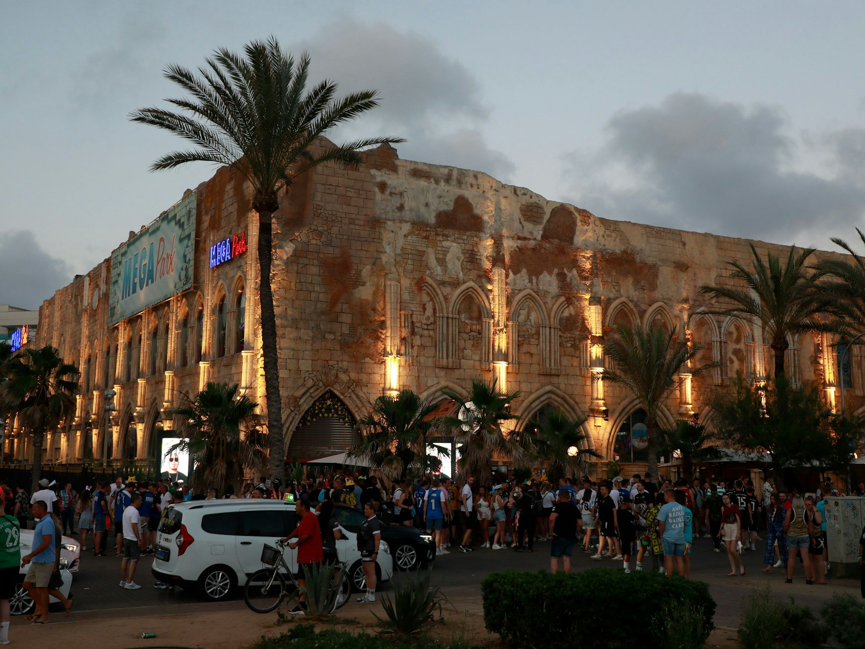 Zahlreiche Menschen stehen vor dem Megapark am Strand von Arenal.