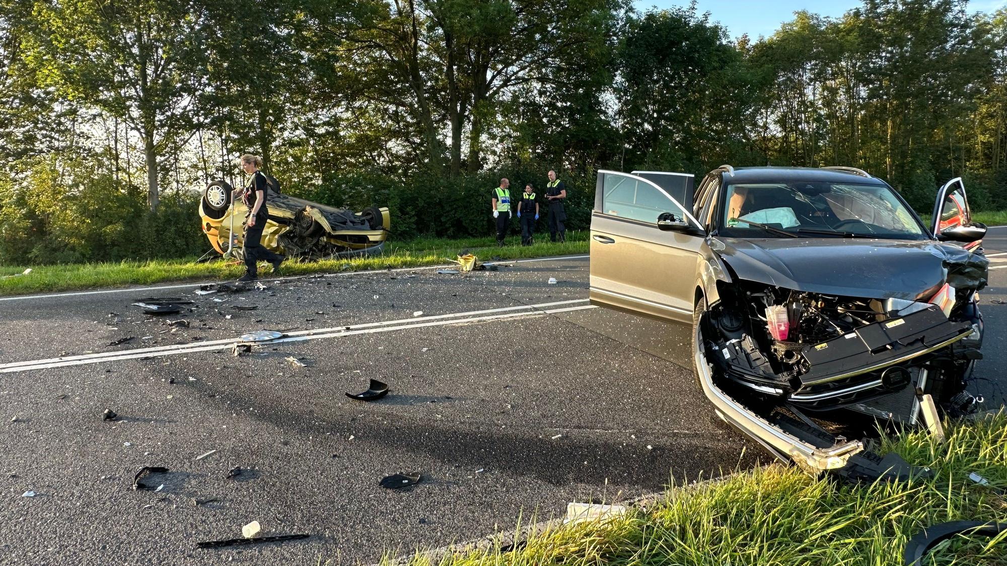 Zwei zerstörte Autos liegen auf einer Straße in Köln nach einem Unfall.