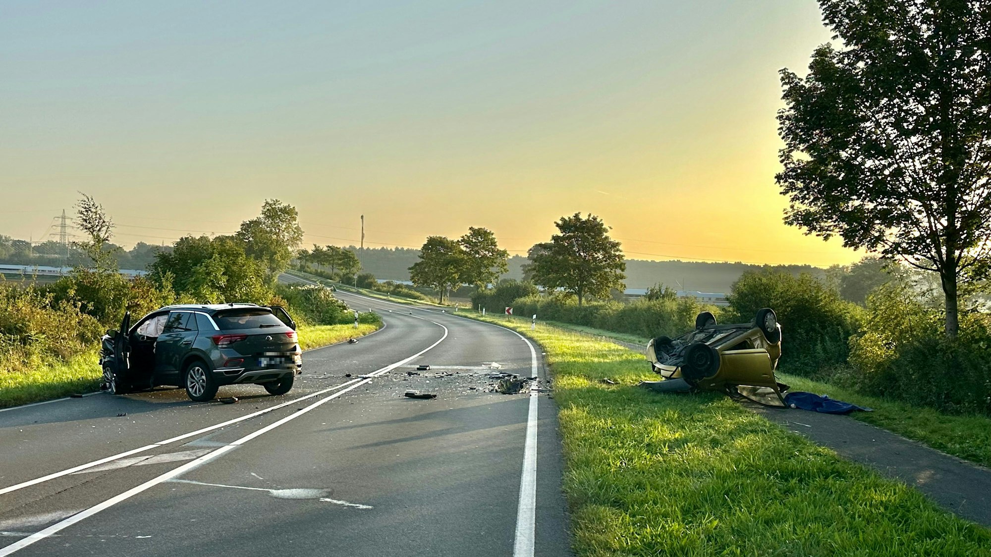 Zwei zerstörte Autos auf einer Landstraße nach einem schweren Unfall.