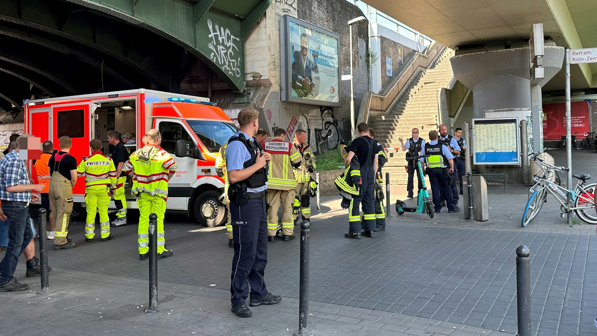 Ein Rettungswagen sowie zahlreiche Einsatzkräfte stehen an der Unterführung des Bahnhofs.
