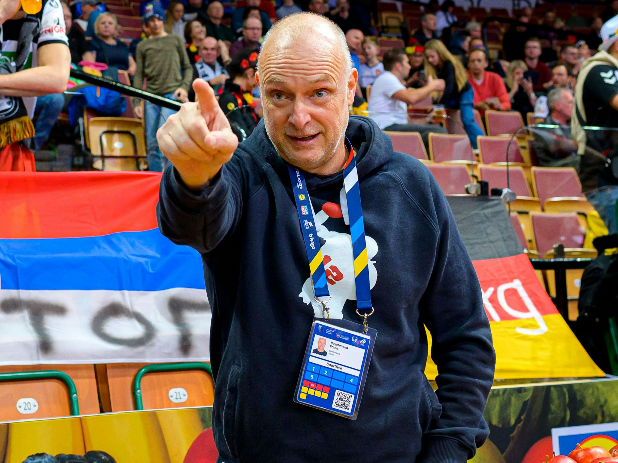 Frank Buschmann zeigt aufs Spielfeld.