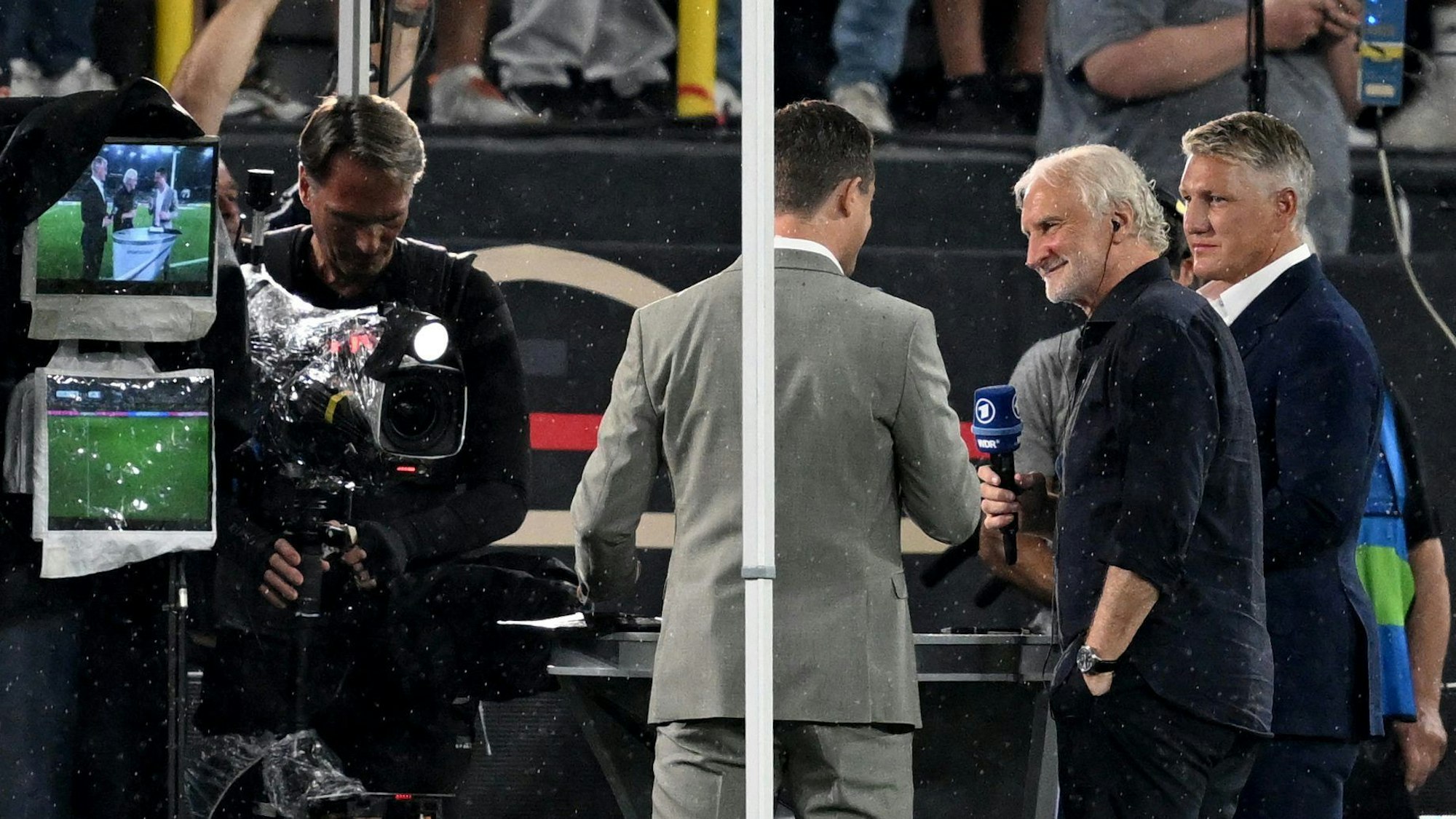 Interims-Teamchef Rudi Völler (Mitte) steht beim TV-Interview neben ARD-Moderator Alexander Bommes (l.) und dem TV-Experten Bastian Schweinsteiger. Die Übertragung wurde kurzfristig verschoben.