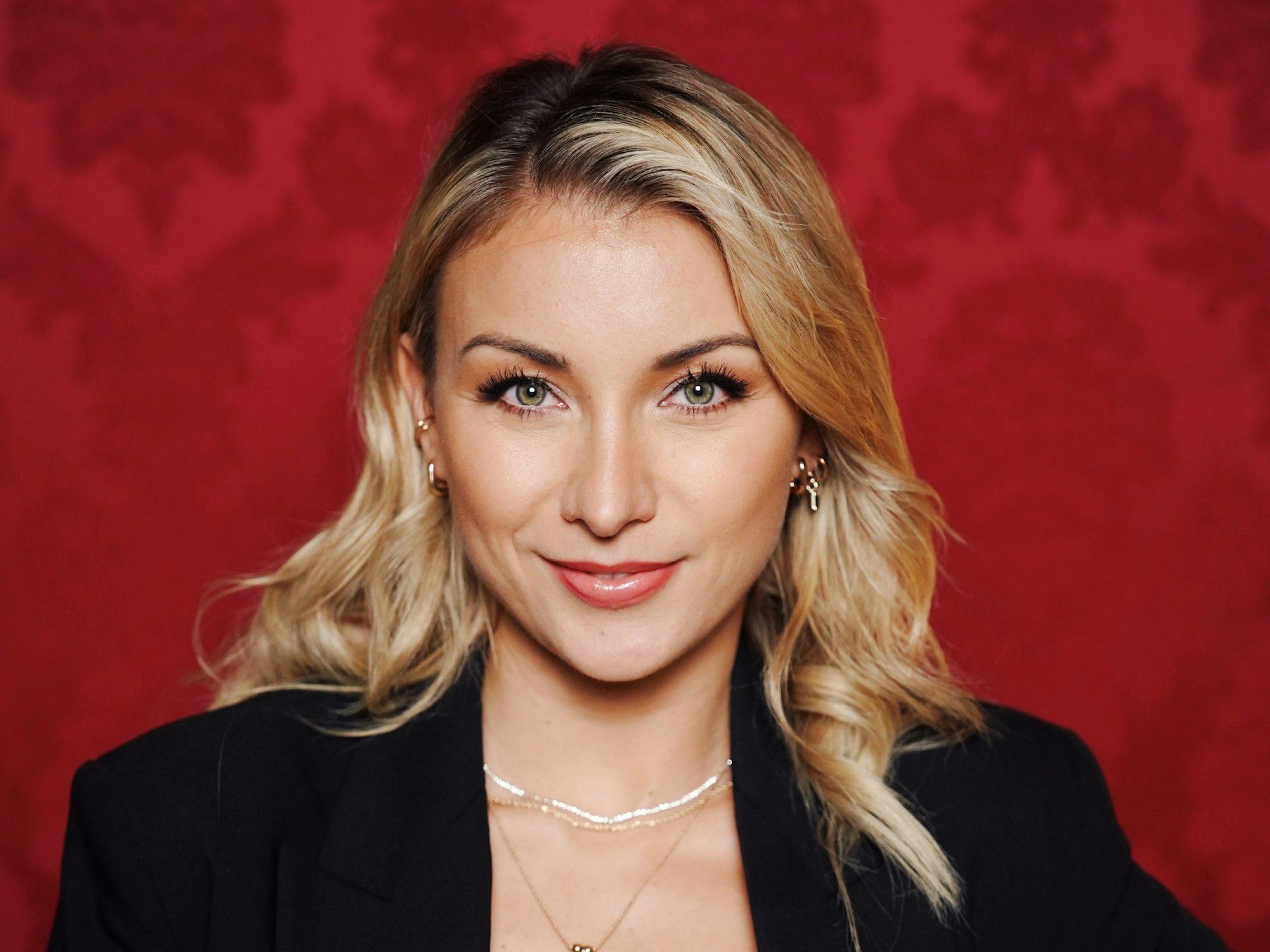 Schlagersängerin Anna-Carina Woitschack posiert vor einer roten Wand auf einem Pressefoto für die RTL-Show "Die Verräter".