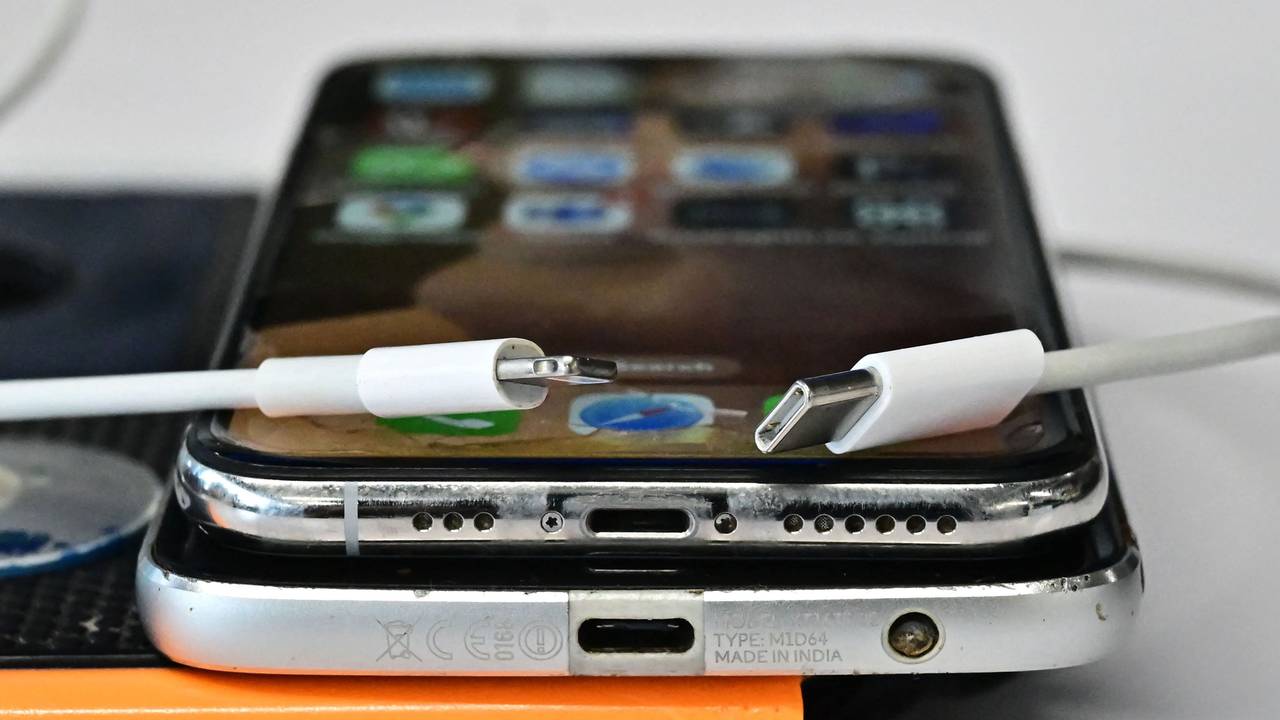 Ein USB-C-Ladegerät (rechts) und ein herkömmliches Apple-Lightning-Ladegerät sind an einem Apple iPhone mit Lightning-Anschluss über einem Android-Telefon mit USB-C-Anschluss zu sehen.