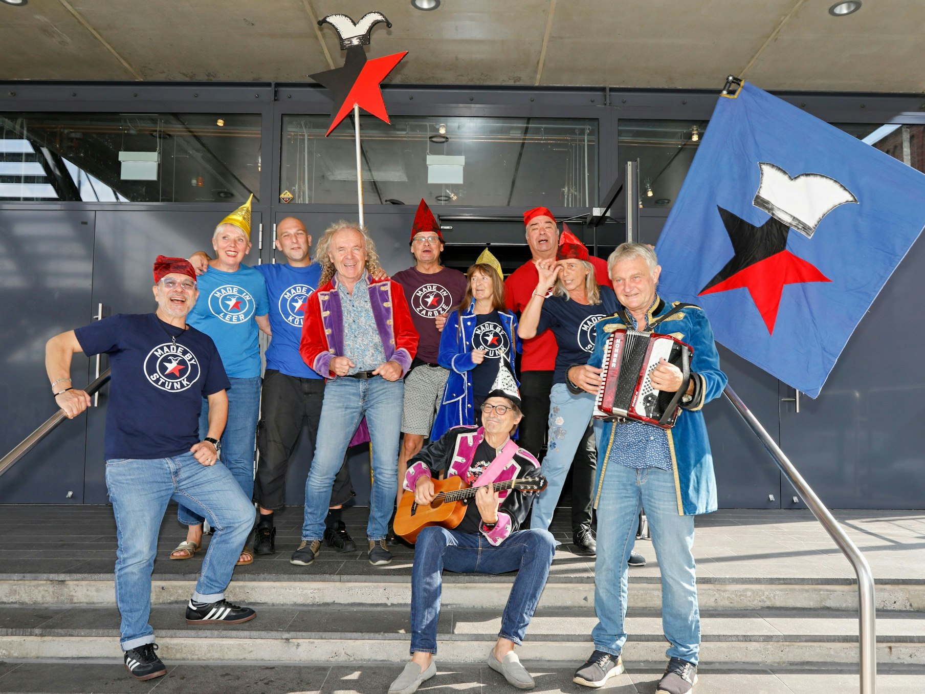 Das Ensemble der Stunksitzung lacht in die Kamera.