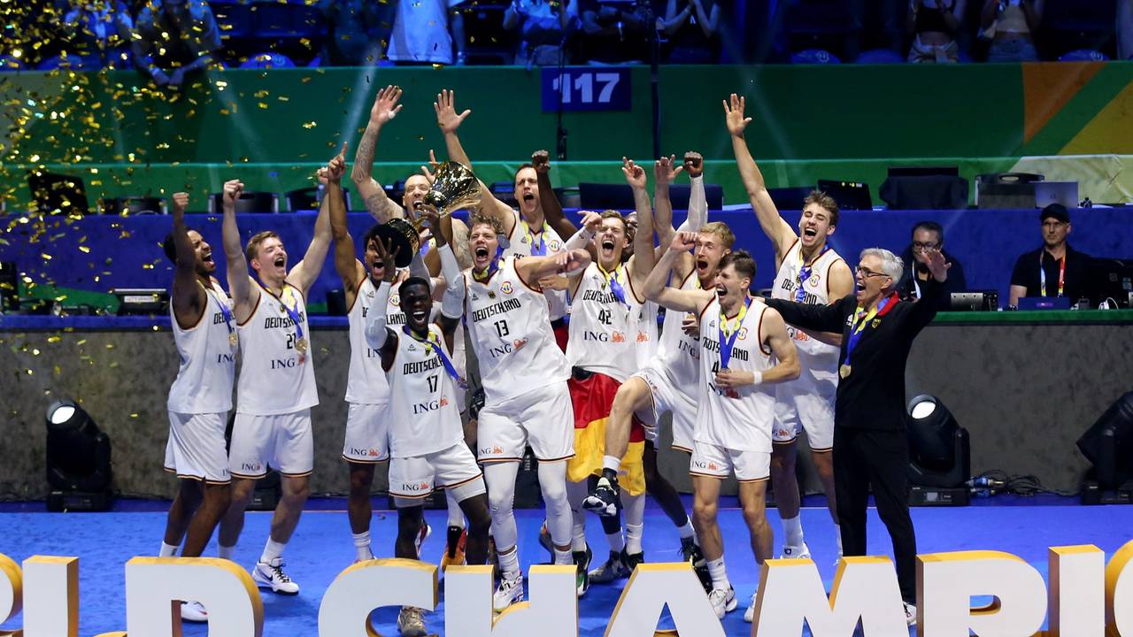 Die deutsche Nationalmannschaft im Basketball feiert mit dem WM-Pokal auf der Bühne.