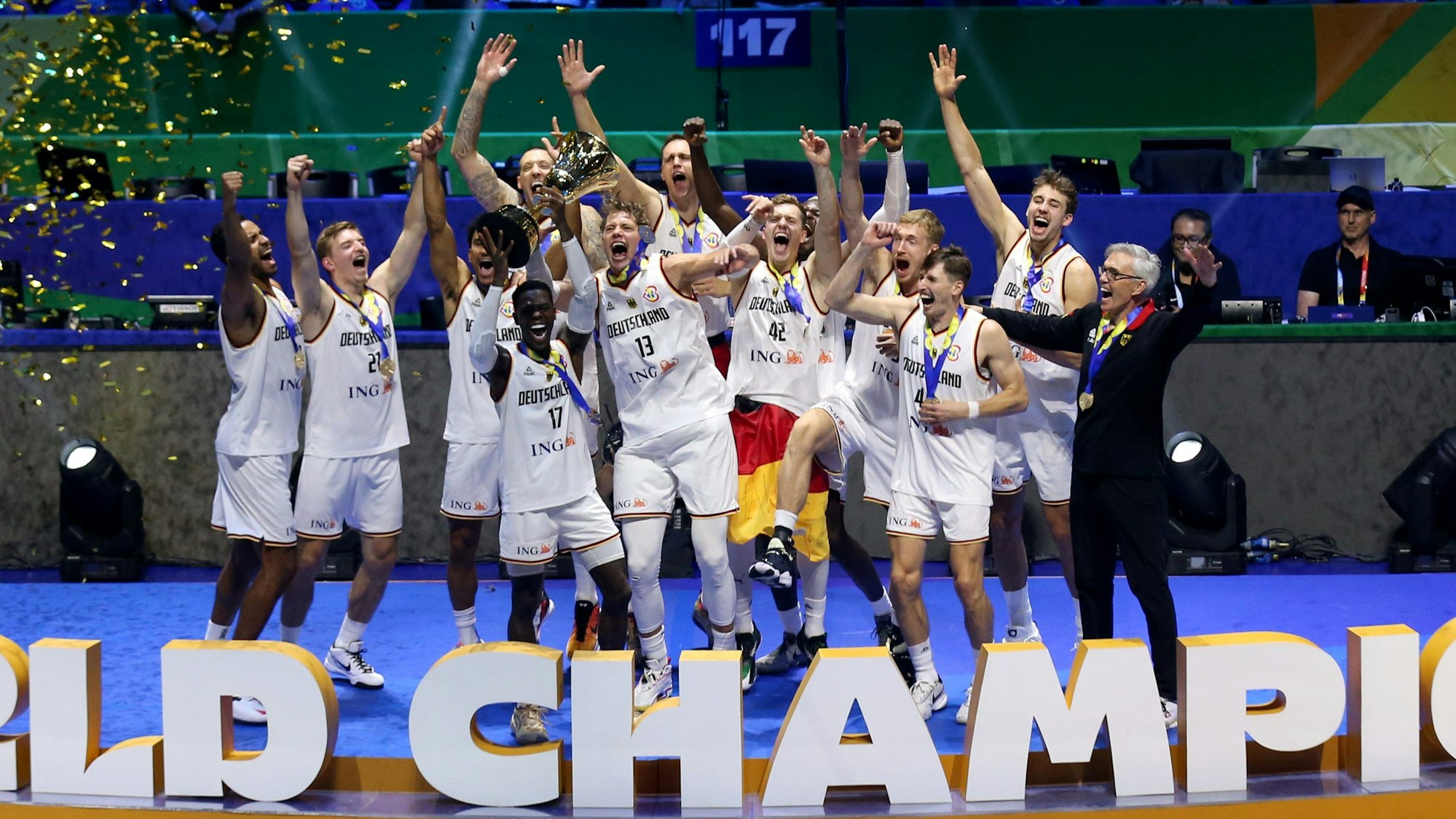 Die deutsche Nationalmannschaft im Basketball feiert mit dem WM-Pokal auf der Bühne.