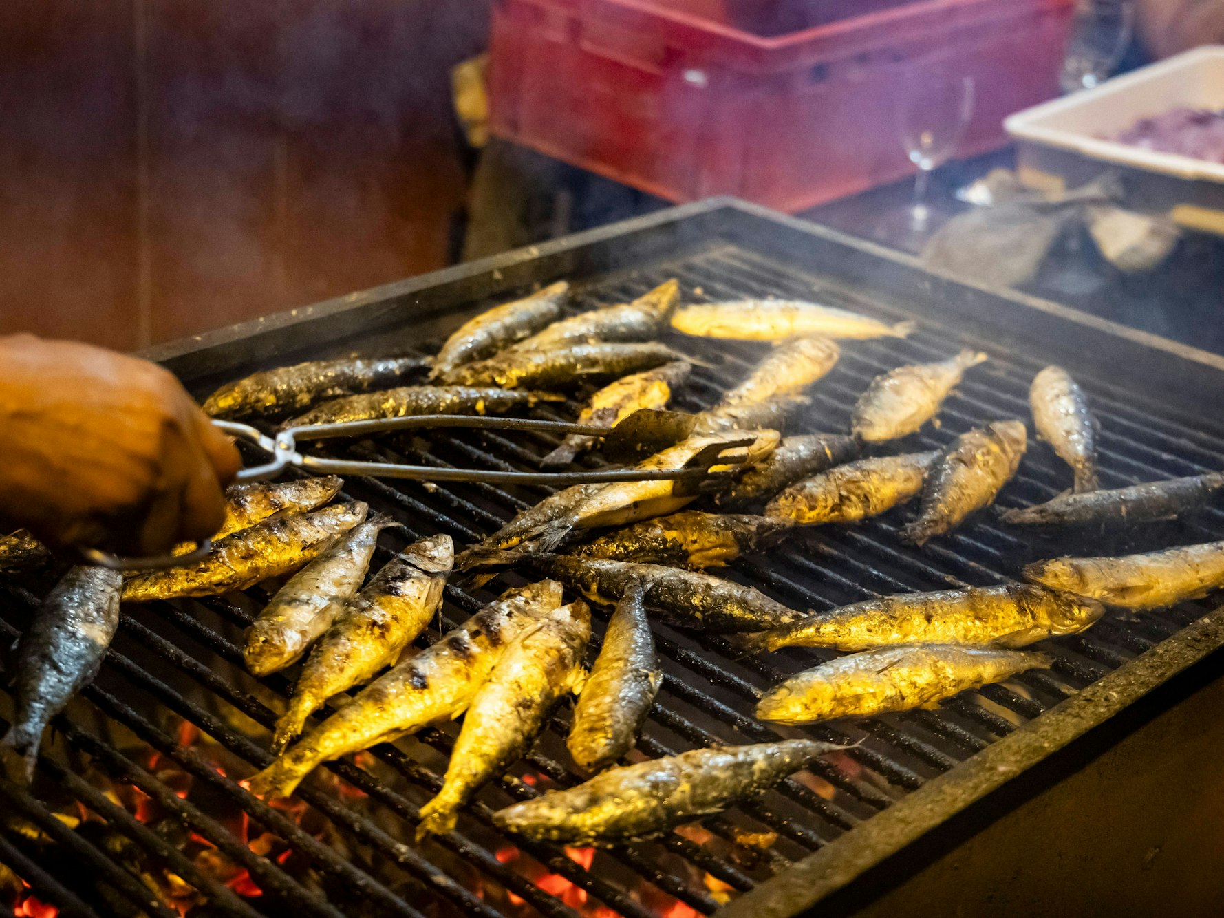 Ein Mann grillt Sardinen in den Straßen von Porto (Portugal).