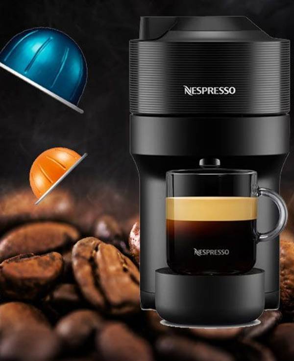 Auf dem Bild ist die angebotene Kaffeemaschine und ein paar der zu kaufenden Kapseln zu sehen.