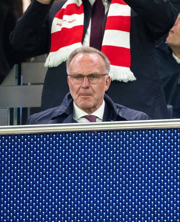 Karl-Heinz Rummenigge und Uli Hoeneß sitzen nebeneinander auf der Tribüne, Hoeneß trägt einen rot-weißen Fanschal.