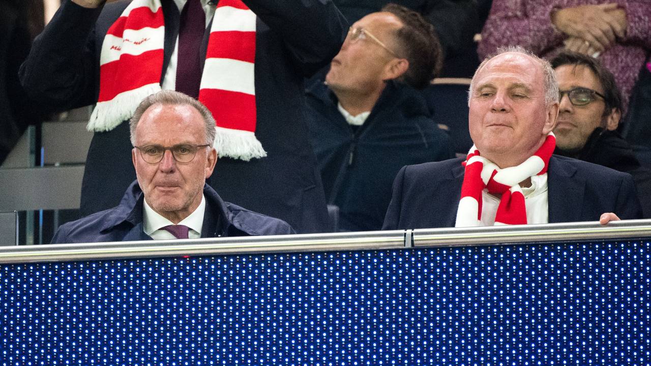 Karl-Heinz Rummenigge und Uli Hoeneß sitzen nebeneinander auf der Tribüne, Hoeneß trägt einen rot-weißen Fanschal.