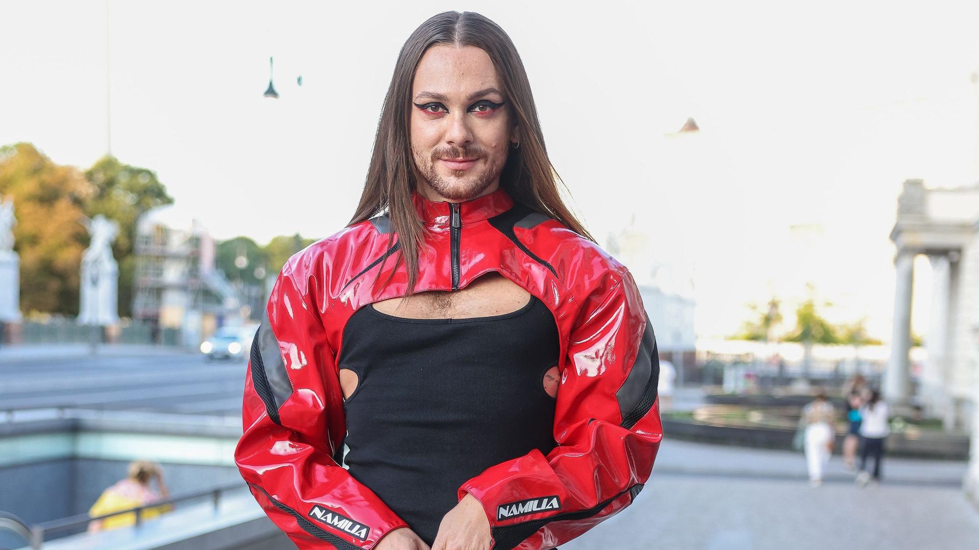 Riccardo Simonetti posiert für die Fotografen. Er trägt ein schwarz-rotes Outfit.