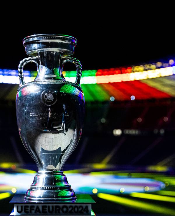 Der Siegerpokal der Fußball-Europameisterschaft 2024 steht im bunt erleuchteten Olympiastadion in Berlin.