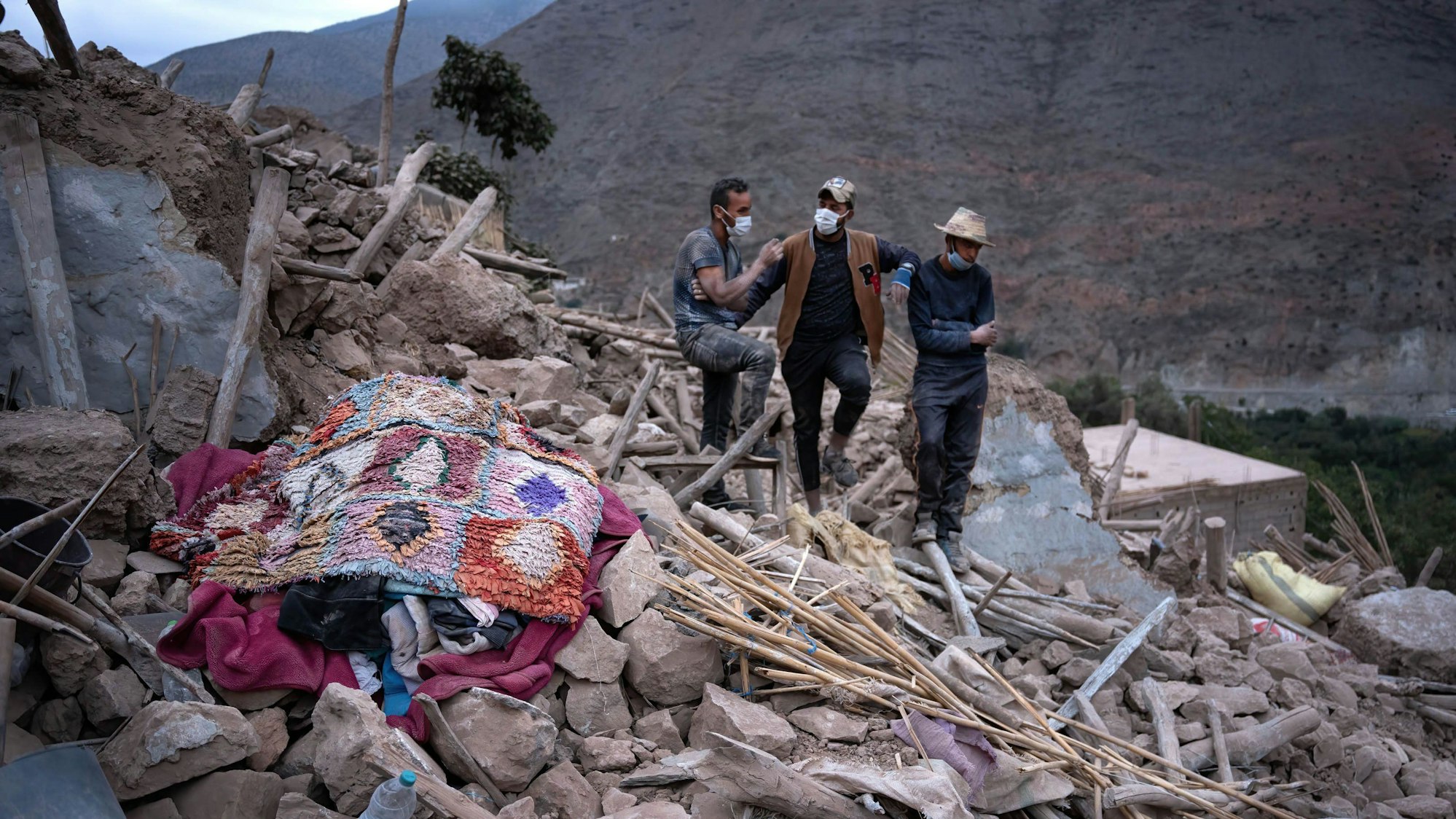 Männer gehen auf den Trümmern eines Hauses in dem kleinen Dorf Imi N'Tala im marokkanischen Atlasgebirge.