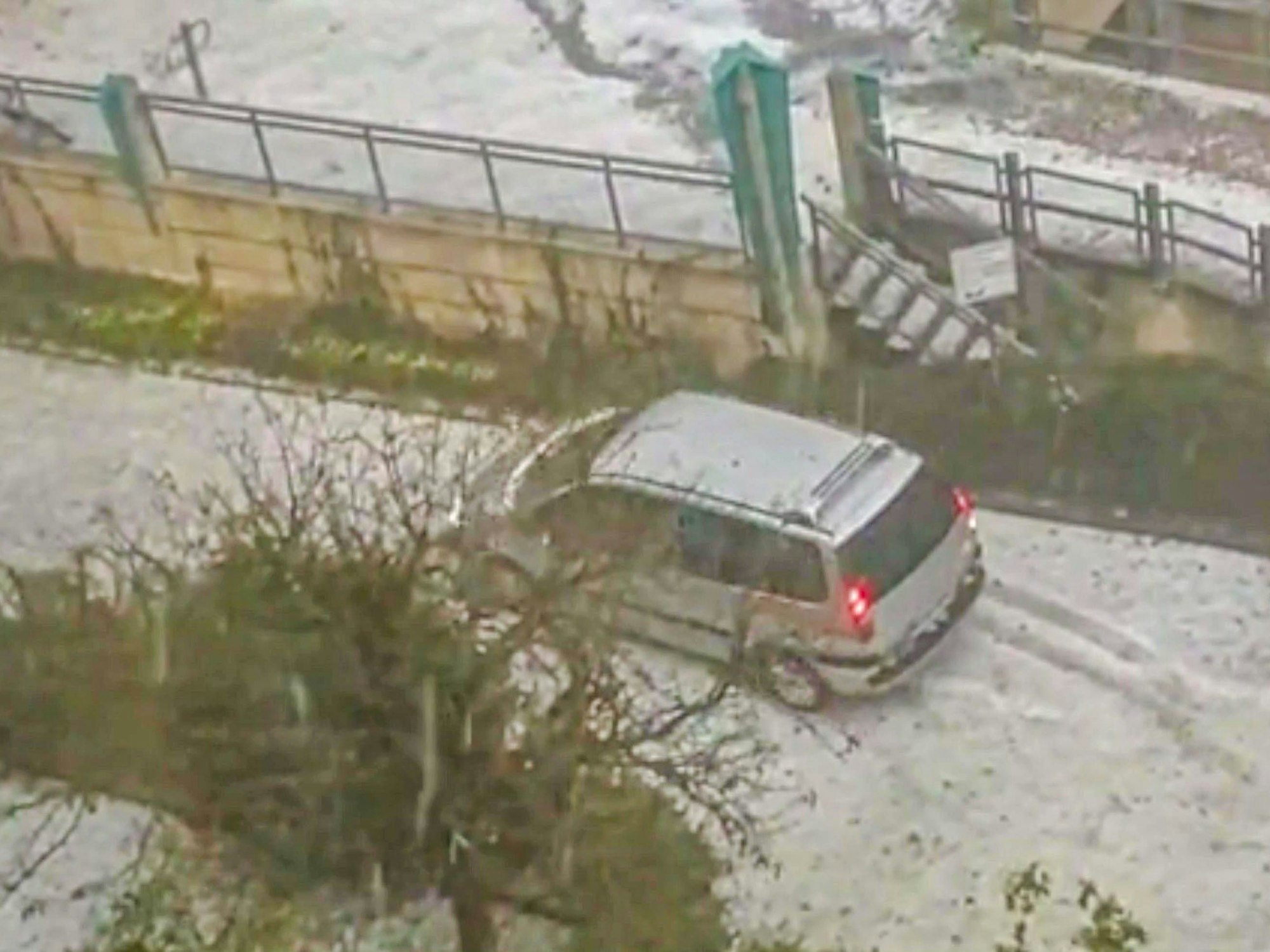 Ein Auto steht inmitten der Hagelmassen in Worms, welche die Stadt in eine Winterlandschaft verwandelte.