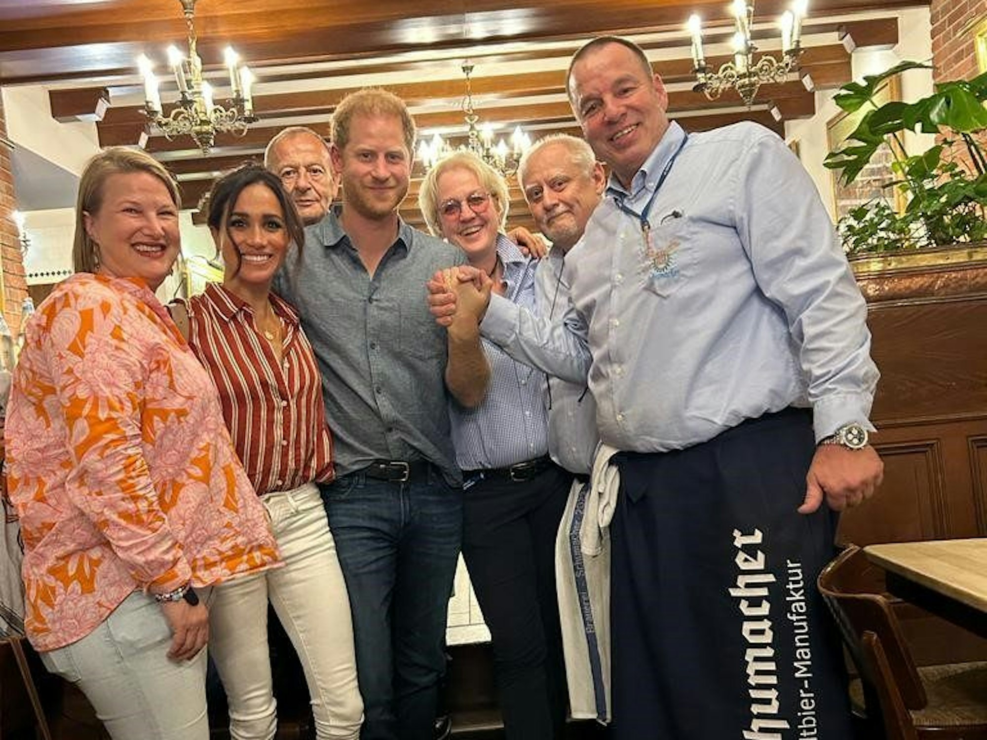 Prinz Harry von Großbritannien und Ehefrau Meghan besuchen in der Altstadt von Düsseldorf eine Brauerei und werden mit einem Teil der Angestellten fotografiert