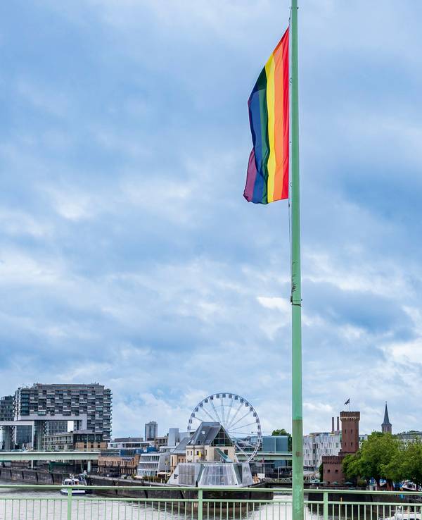 Eine Regenbogenfahne hängt auf der Deutzer Brücke in der Kölner Innenstadt.