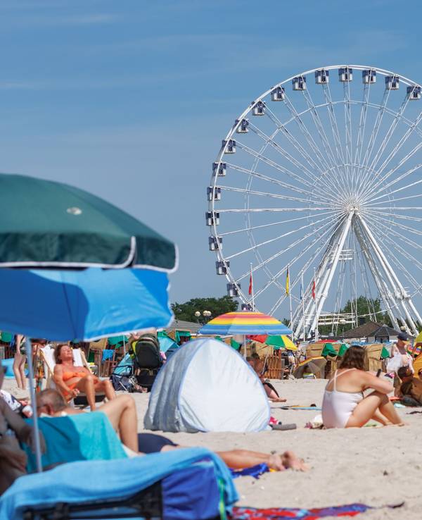 Urlaubende genießen den Sommer am Ostseestrand in Grömitz.