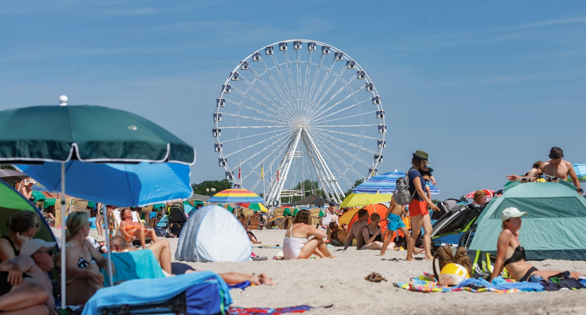 Urlaubende genießen den Sommer am Ostseestrand in Grömitz.