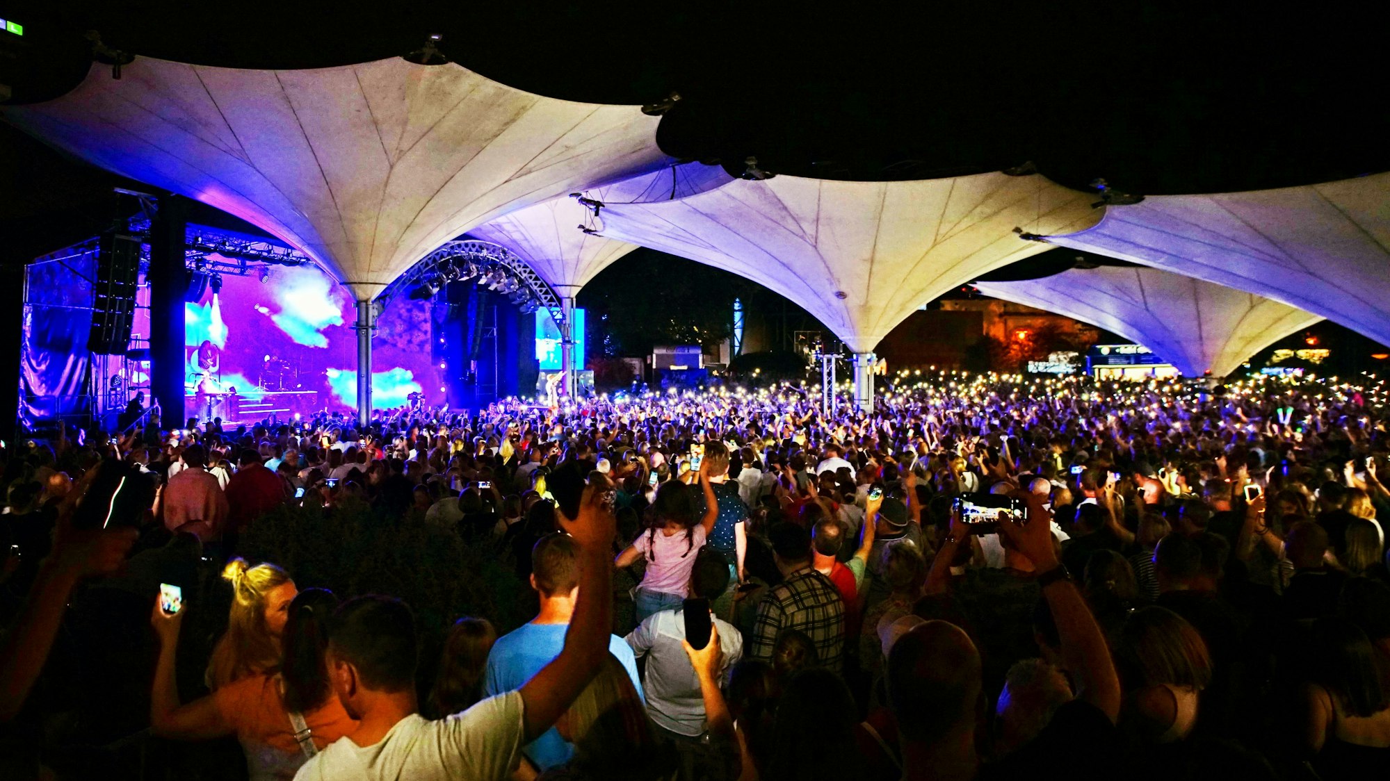 10.000 Menschen stehen im Kölner Tanzbrunnen und erleuchten mit ihren Handys die Nacht.