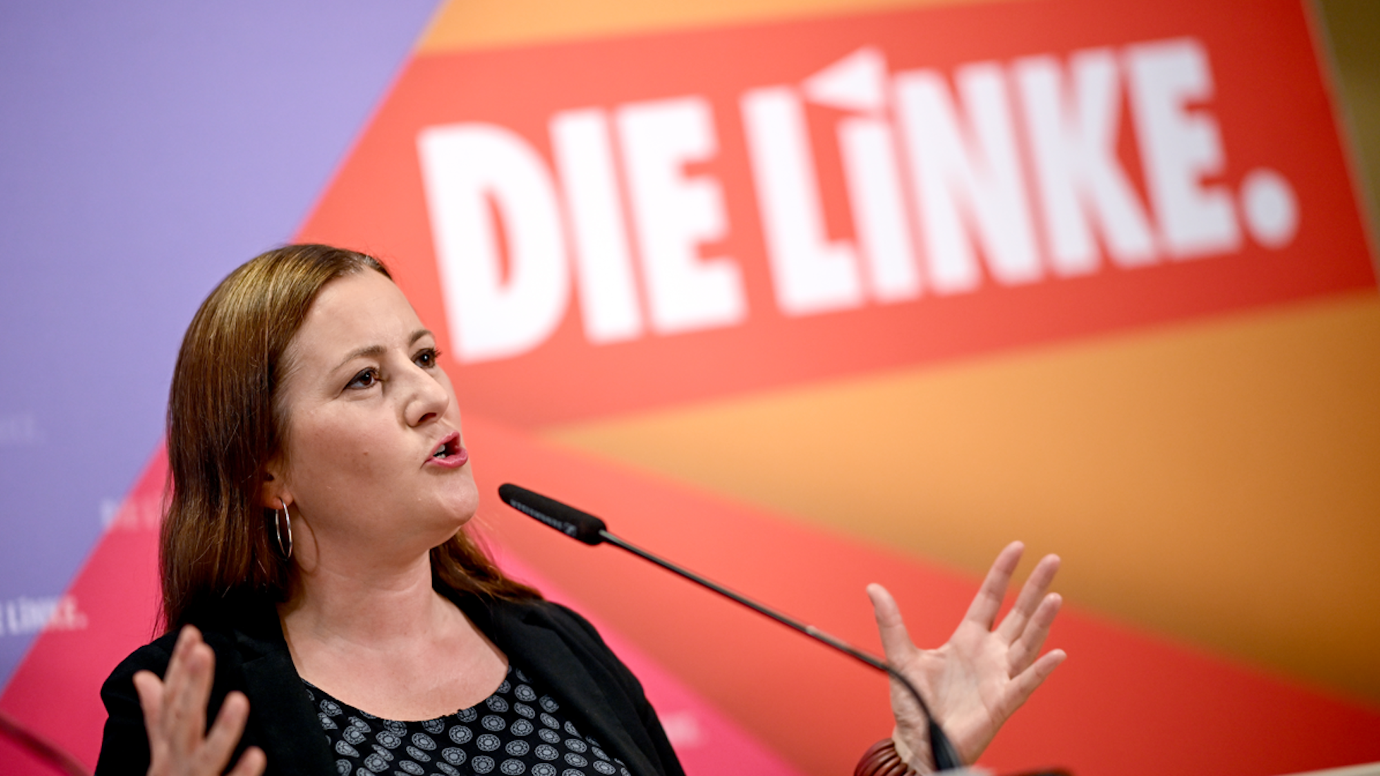 Janine Wissler spricht am Pult in ein Mikrofon.