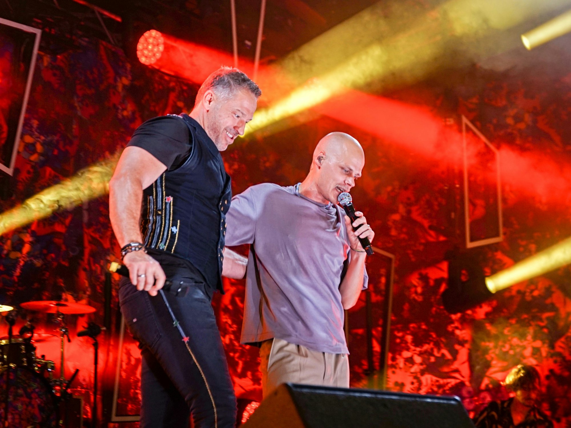 Patrick Lück und Oliver Niesen stehen mit Mikrofonen gemeinsam auf einer Bühne.