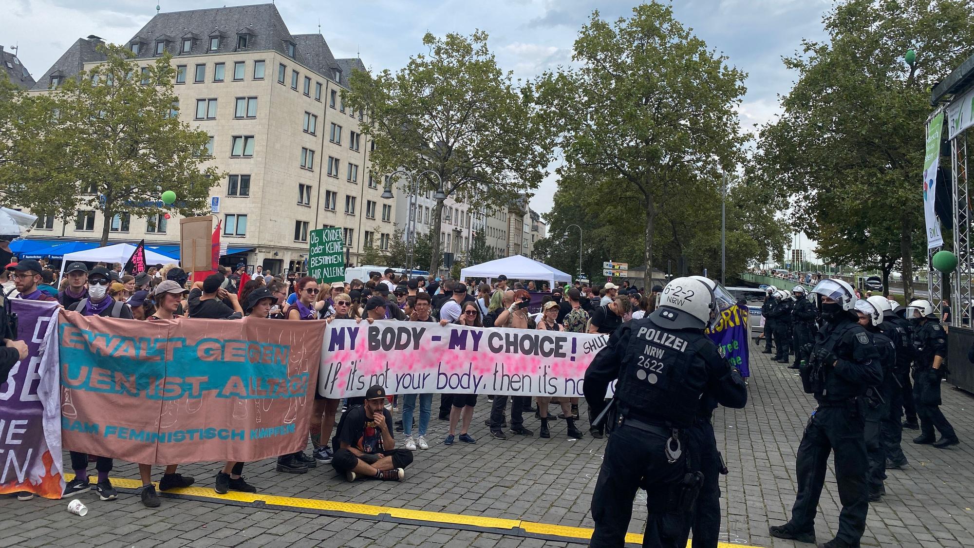 Demo-Teilnehmende stehen am Heumarkt in Köln Einsatzkräften der Polizei gegenüber.