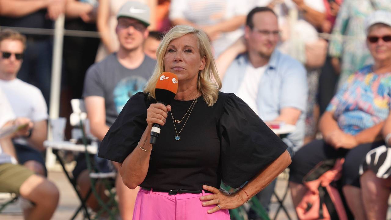 „Fernsehgarten“-Moderatorin Andrea Kiewel steht mit einem Mikrofon in der Hand auf der Bühne.