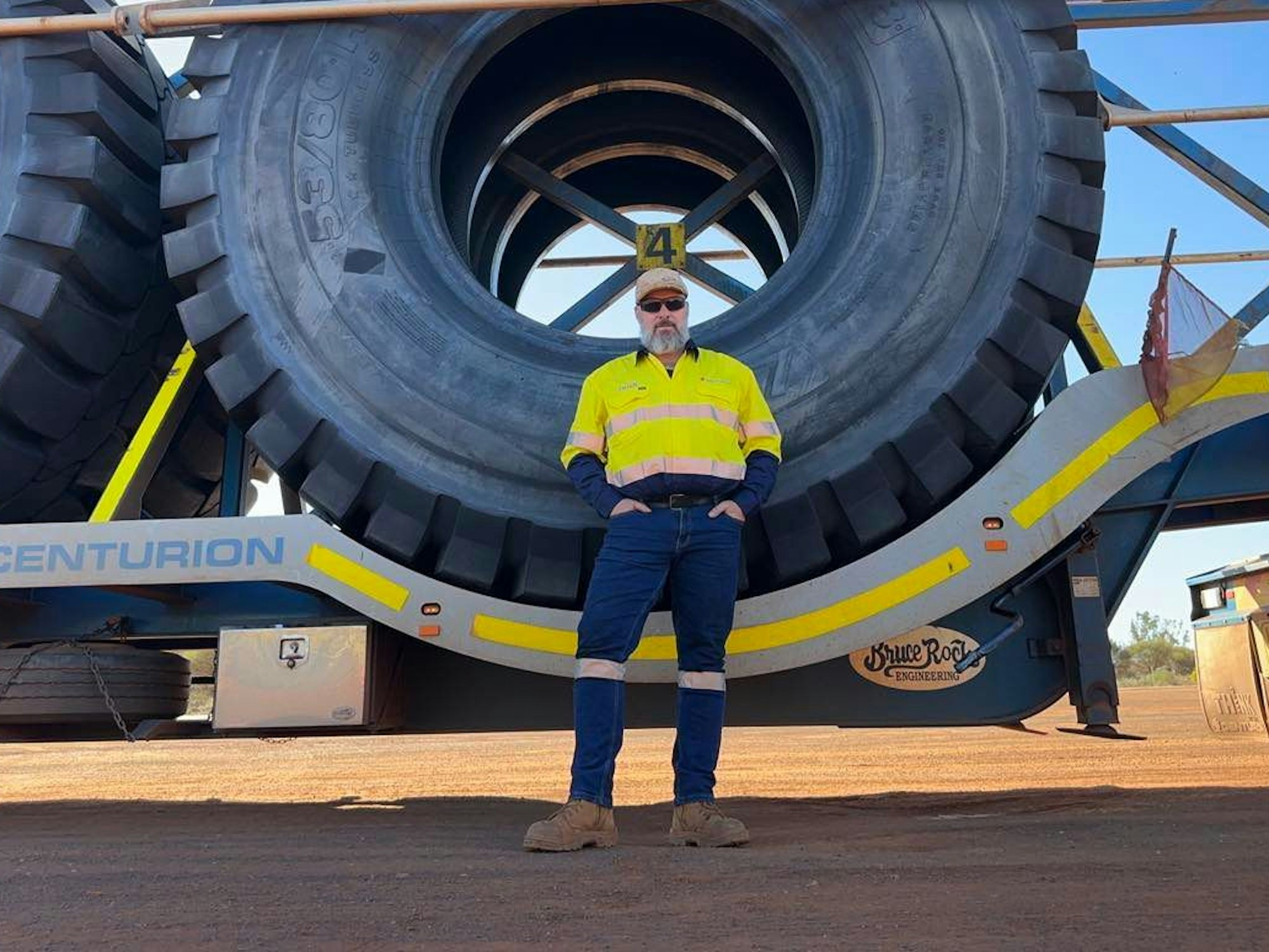 Der deutsche Fernlastfahrer Ingo Zacharias steht vor riesigen Reifen, die er auf seinem „Road Train“ durch 1600 Kilomater durch Australien transportiert.