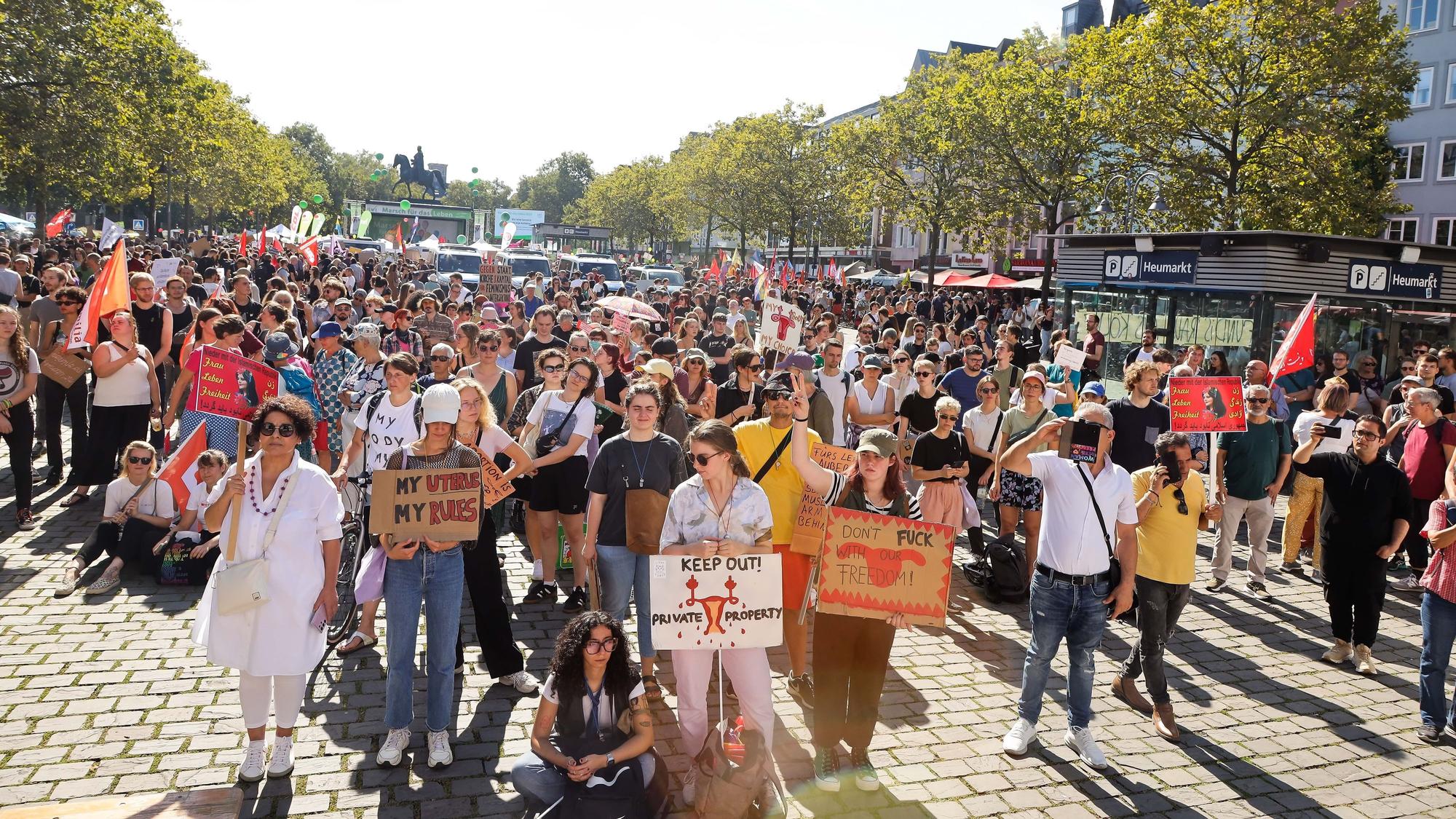 Hunderte Menschen stehen mit Plakaten auf dem Heumarkt in Köln.