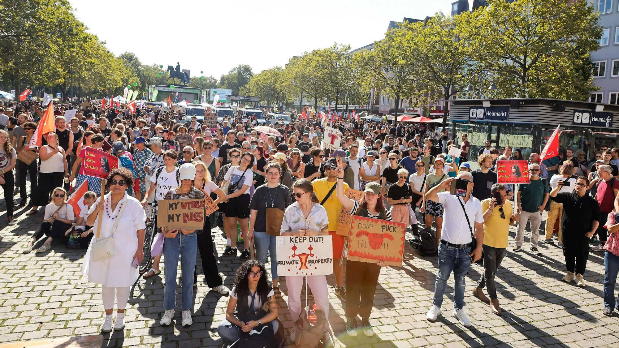 Hunderte Menschen stehen mit Plakaten auf dem Heumarkt in Köln.
