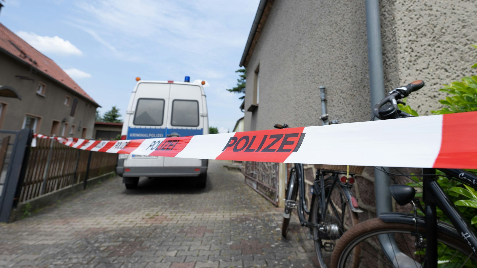Ein Absperrband hängt vor einem Wohnhaus.