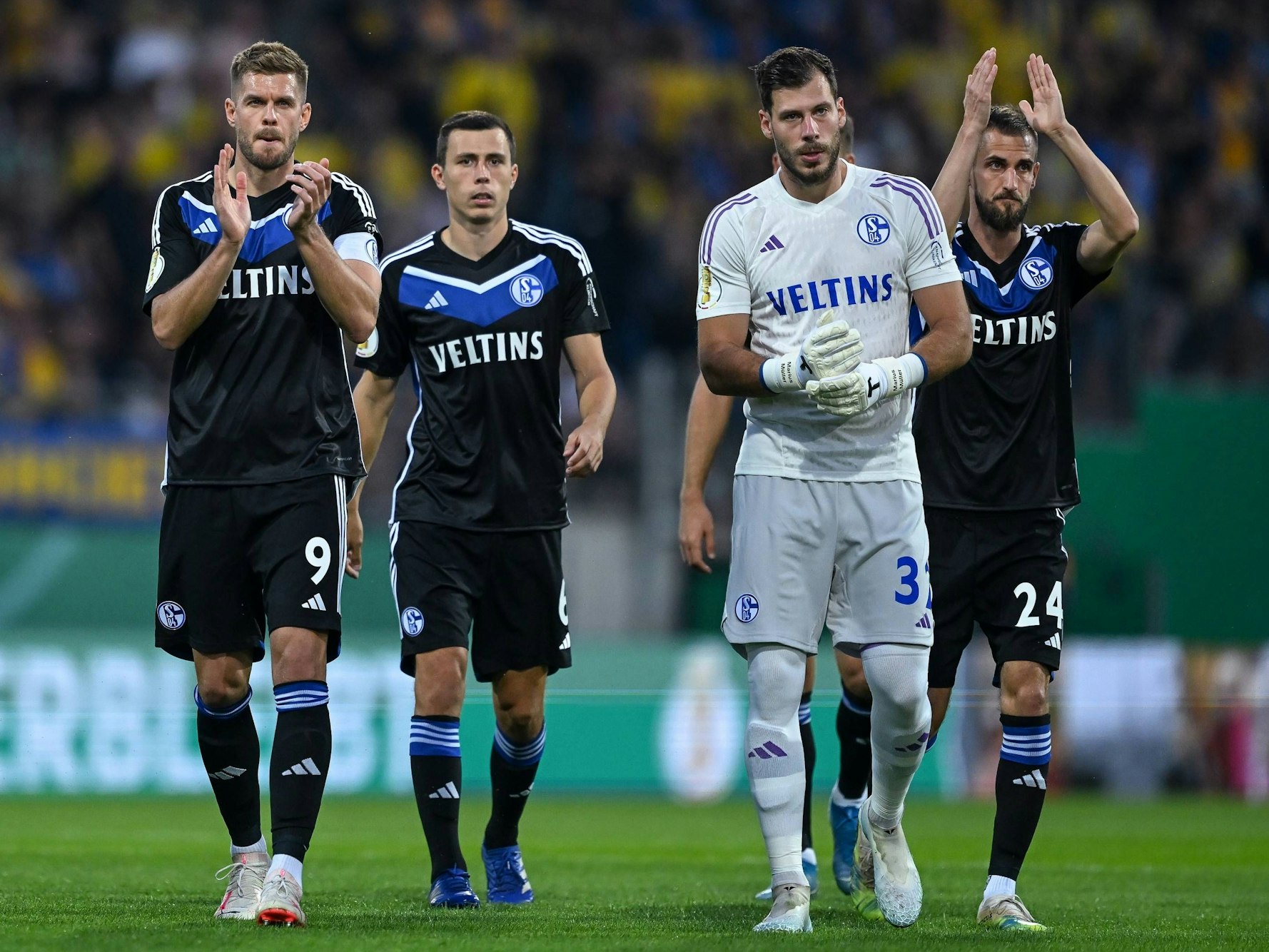 Die Schalke-Profis Simon Terodde, Ron Schallenberg, Marius Müller und Dominick Drexler laufen in Richtung Schalke-Kurve.