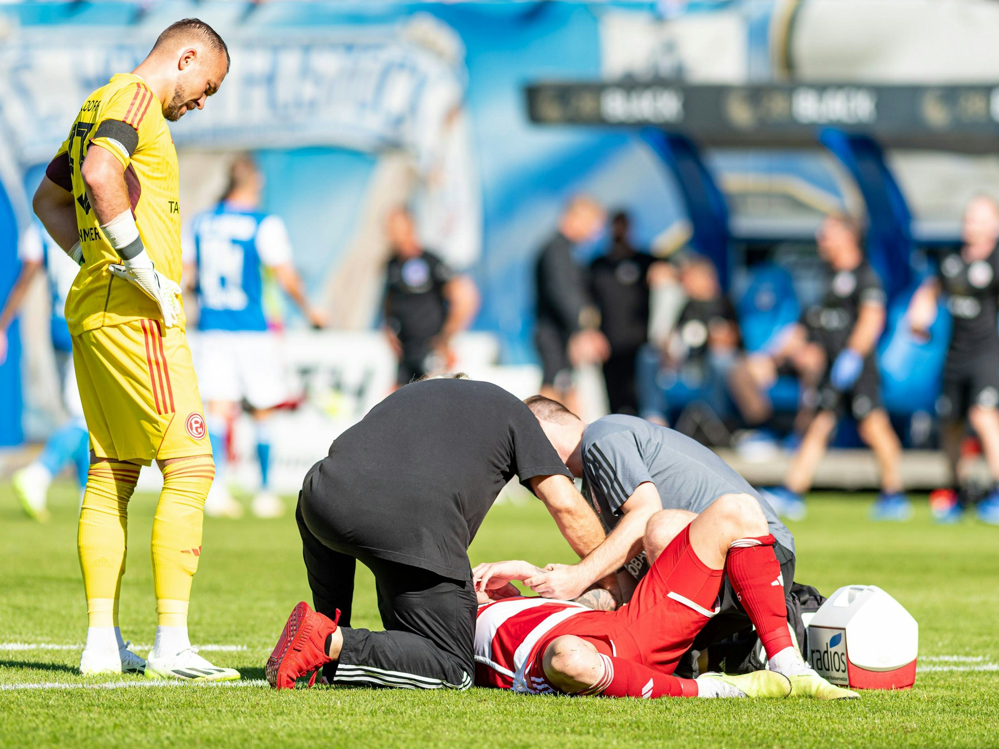 Andre Hoffmann wird behandelt, Kastenmeier schaut zu.