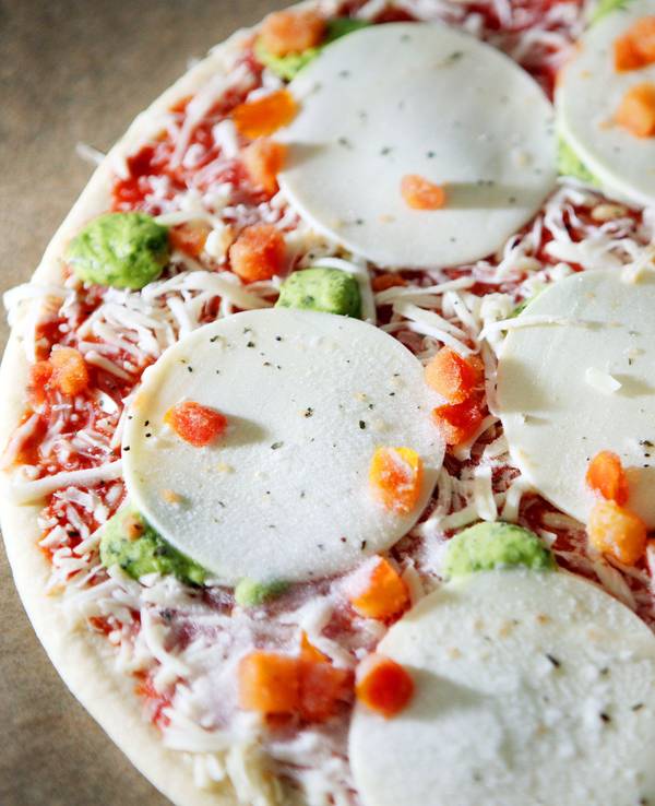 Eine Tiefkühlpizza liegt auf einem Backblech (Symbolfoto).